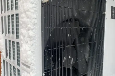 Unité extérieure de pompe à chaleur en fonctionnement sous la neige